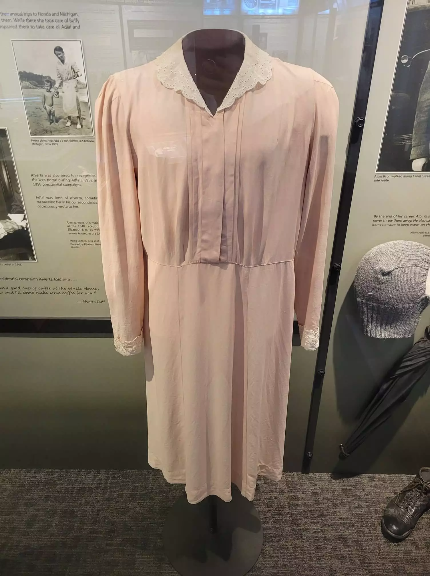 a long-sleeved light pink dress with white collar.