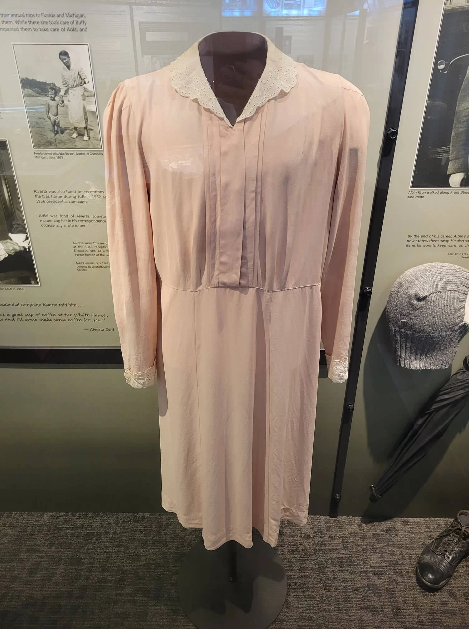 a long-sleeved light pink dress with white collar.