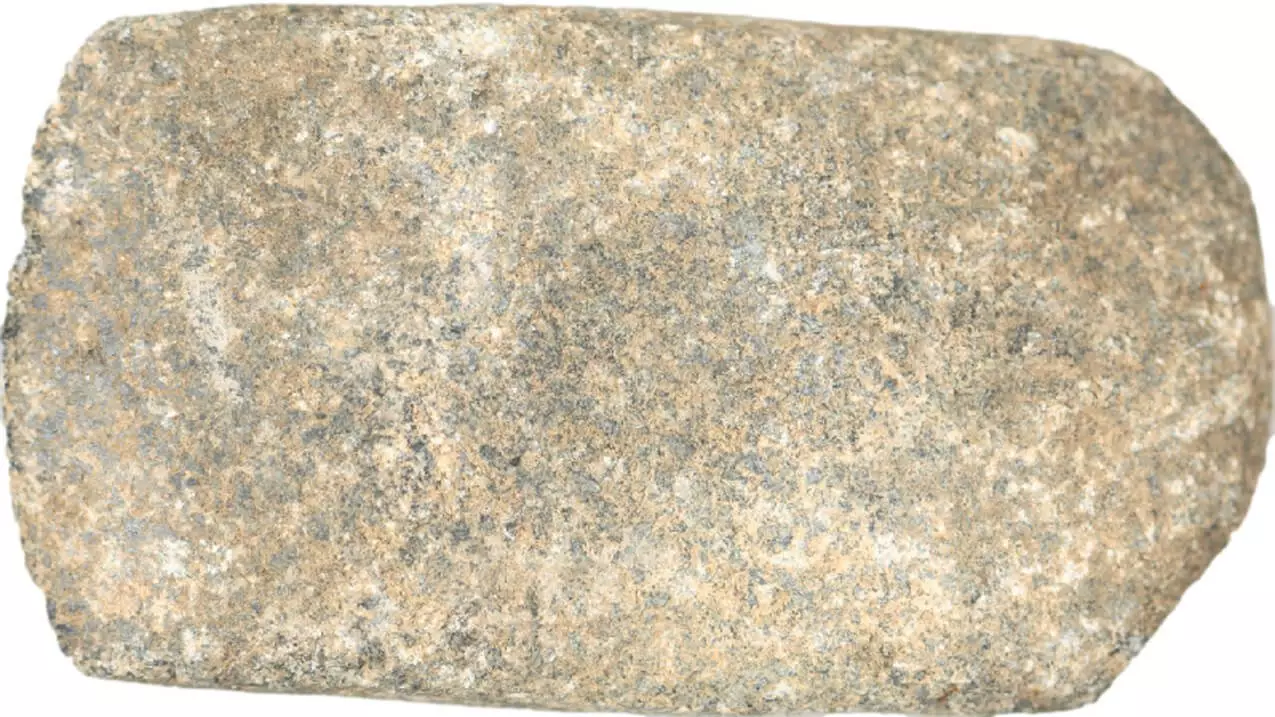 Grainy brown-gray stone. Rectangular and somewhat flatter than other celts.
