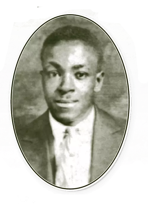 A young African American man looks into the camera with a closed-mouth smile. He is wearing a suit and tie.