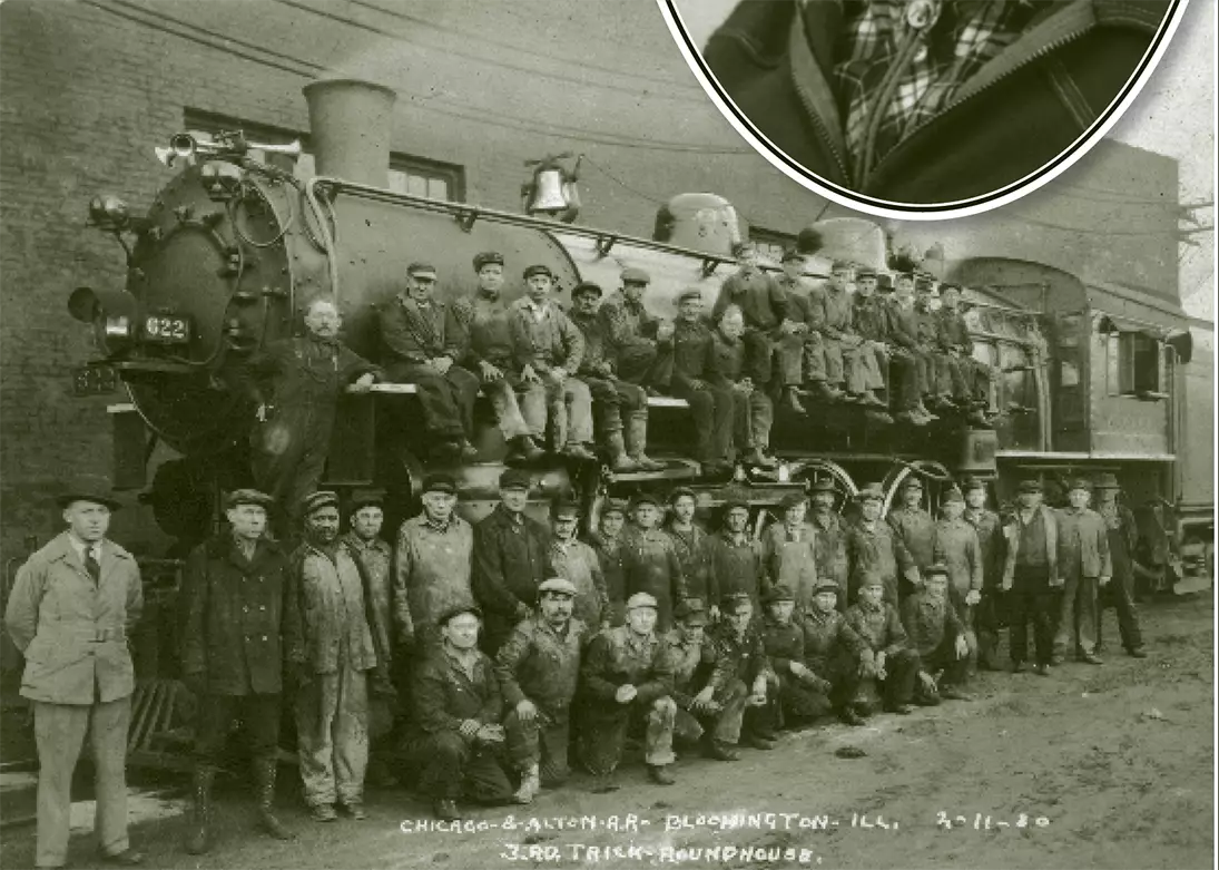 Group photo of over 4 men standing in front of or sitting on top of a train locomotive outdoors.