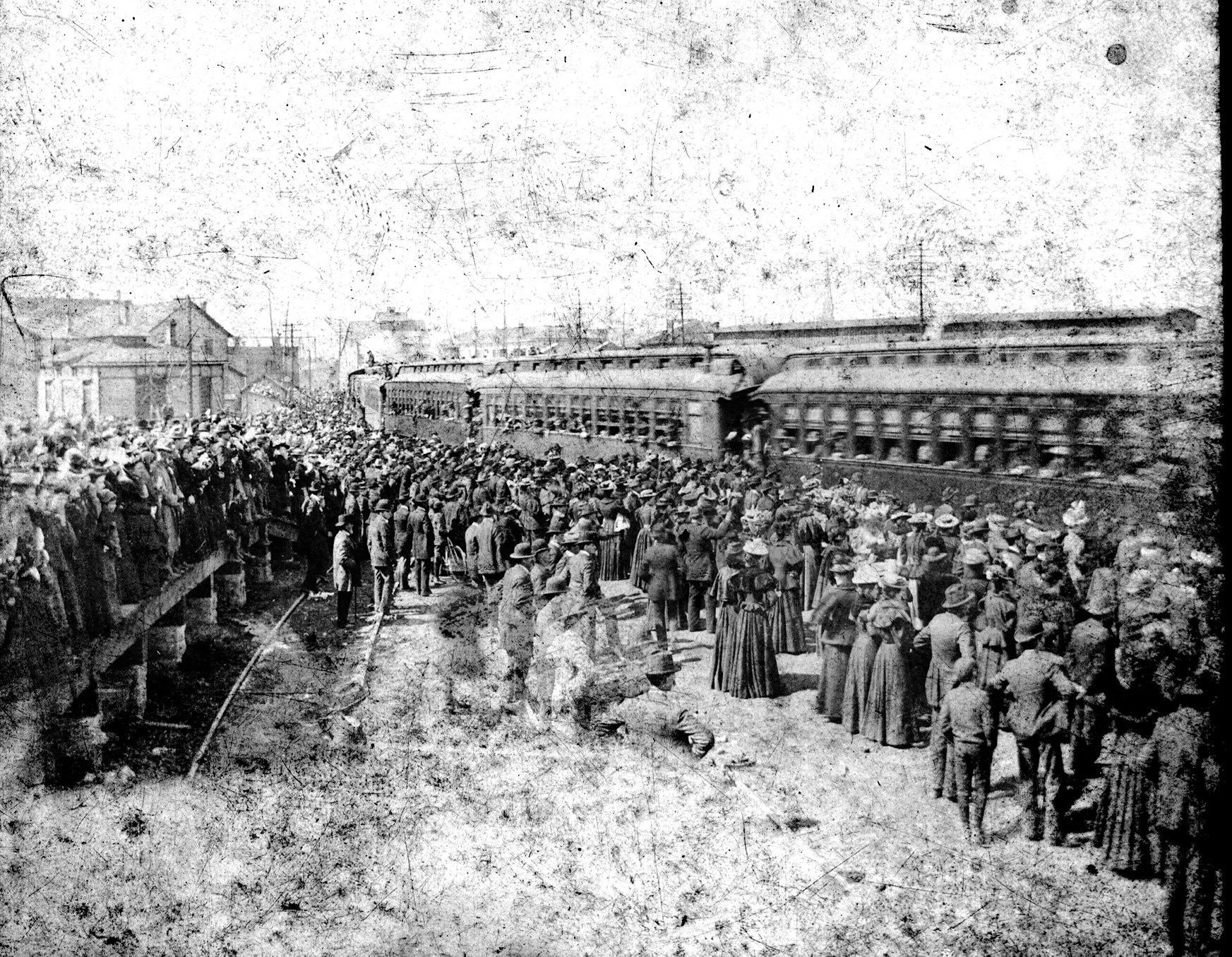 Photo of a very large crowd, gathered around a train