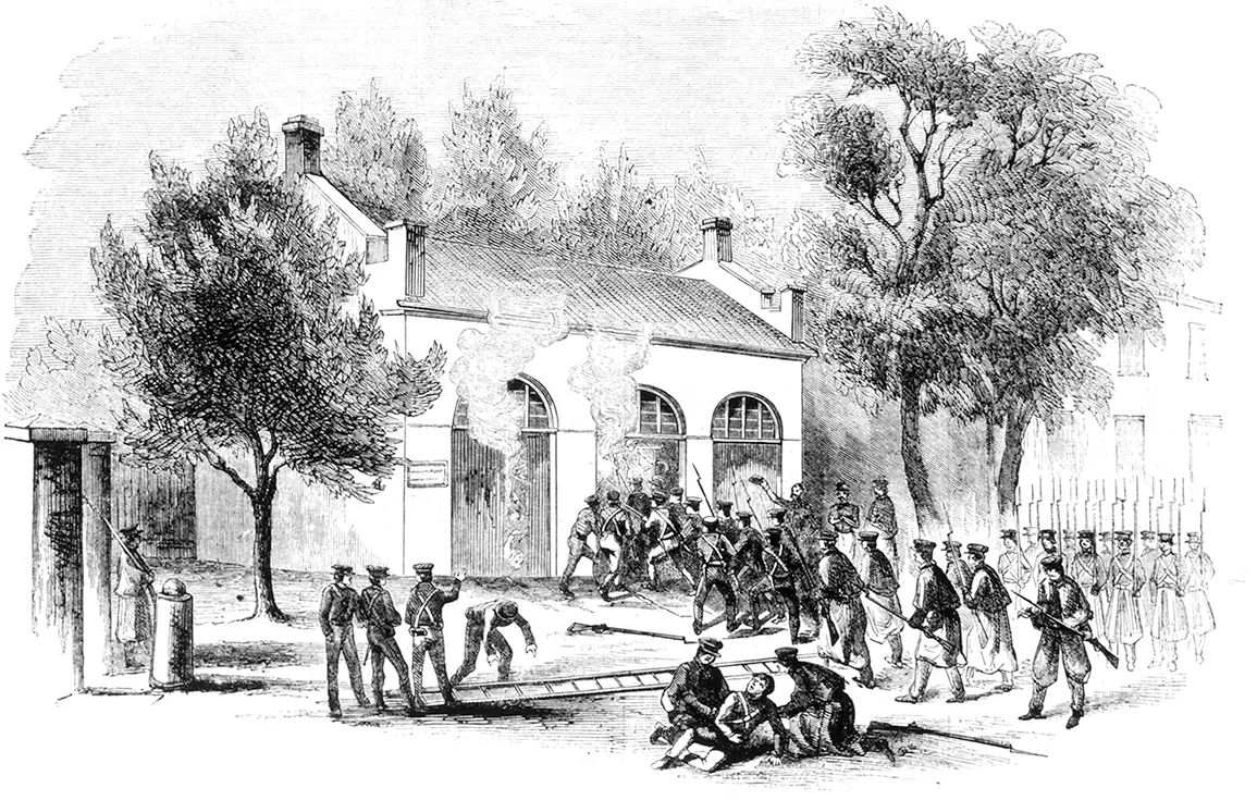 Black and white illustration of men in military uniform, seizing a burning building: the U.S. arsenal at Harpers Ferry, Virginia. Smoke comes up from the windows and the scene looks chaotic, with some men charging, some men marching, and one man in the center, lying wounded.