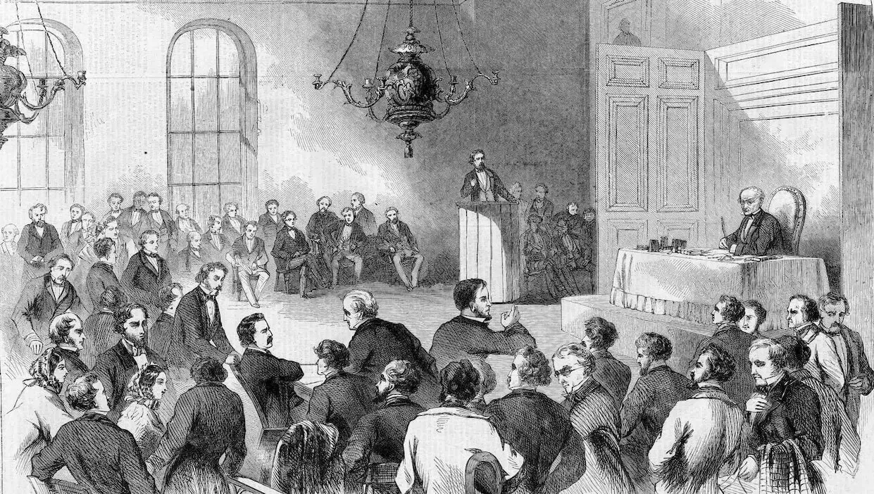 A black and white drawing of a courtroom full of men. One man is at the stand, and the judge looks on the crowd from his table at the front of the room.