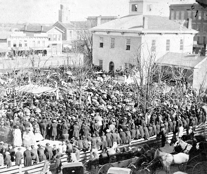 Black and white photo of a large crowd outside a courthouse.