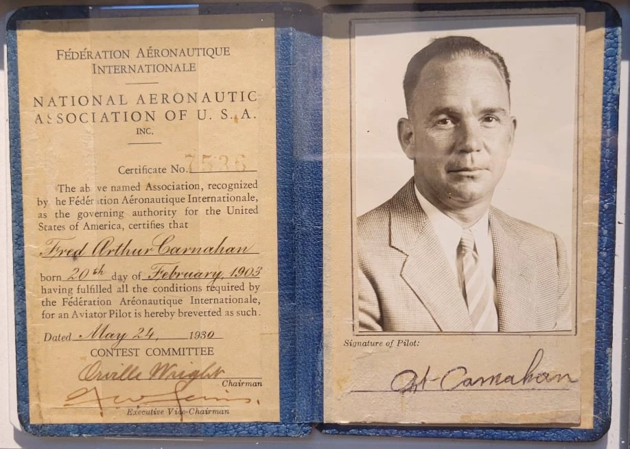 A small blue book containing Art's pilot's license, which is a small certificate signed by the National Aeronautic Association of USA Contest Committee May 1930. On the right is his portrait and signature.