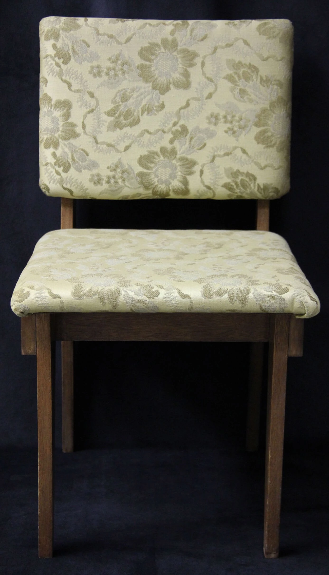 Photo of a wooden chair with a floral fabric seat and back.
