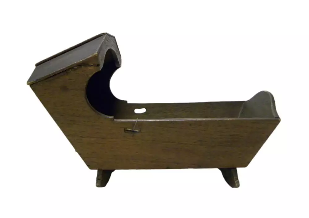 Photo of a dark wood simply-designed doll cradle.
