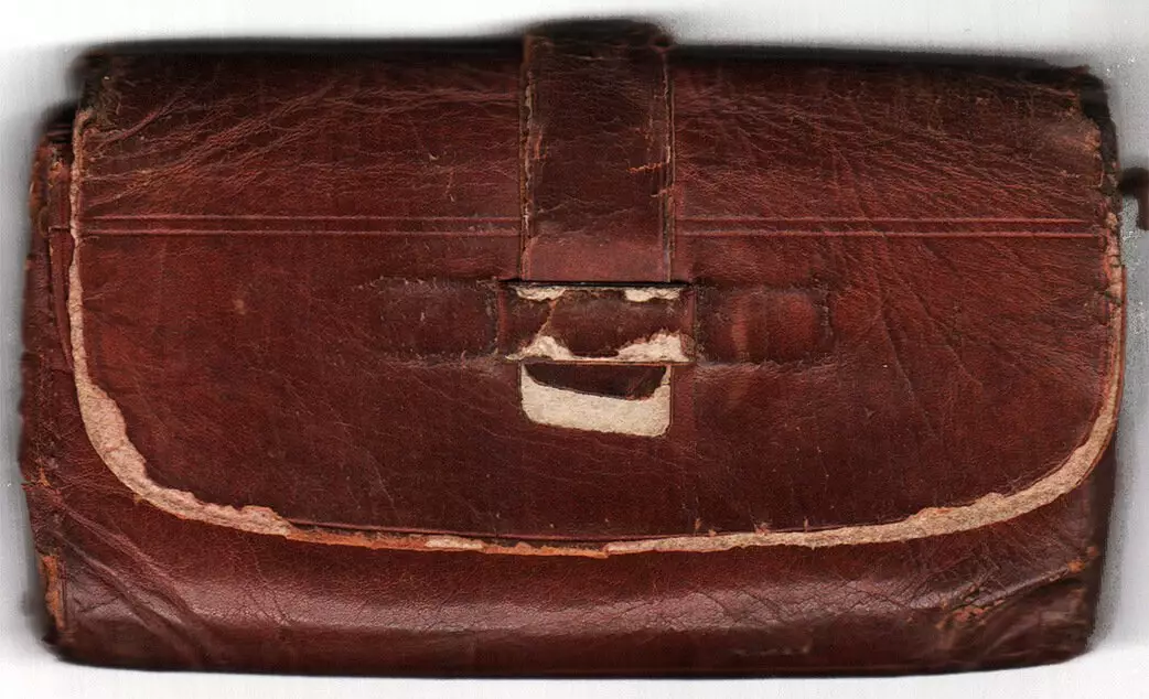 Photo of a brown leather clutch that folds closed.