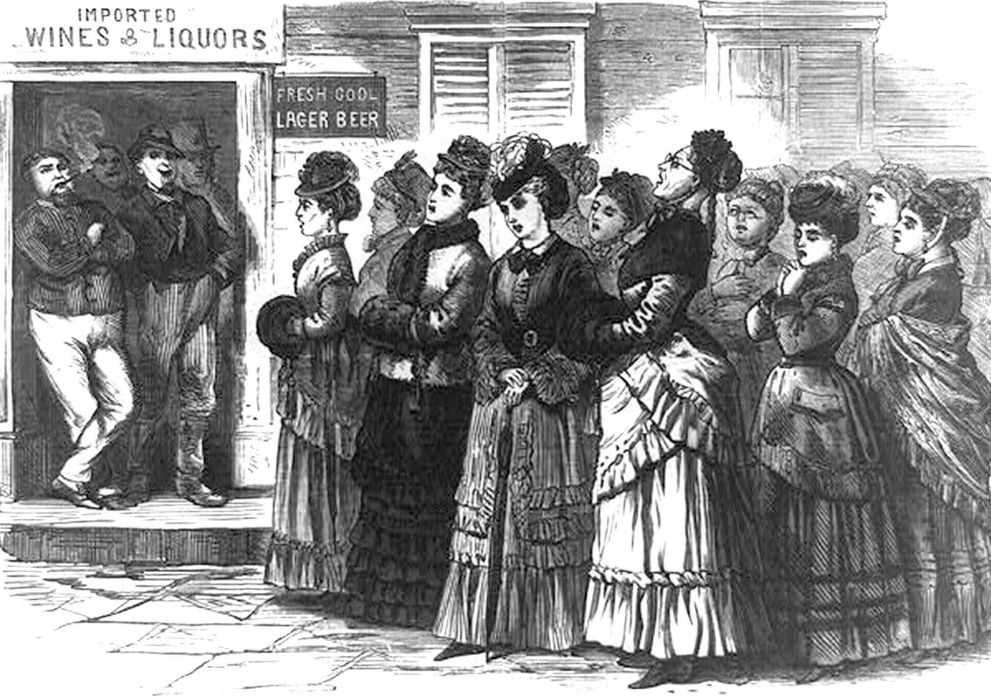 Large group of women in dresses stand outside a saloon. Saloon has a 'fresh cool lager beer' sign in the window. A group of men stands in the door, smoking and looking on in contempt.