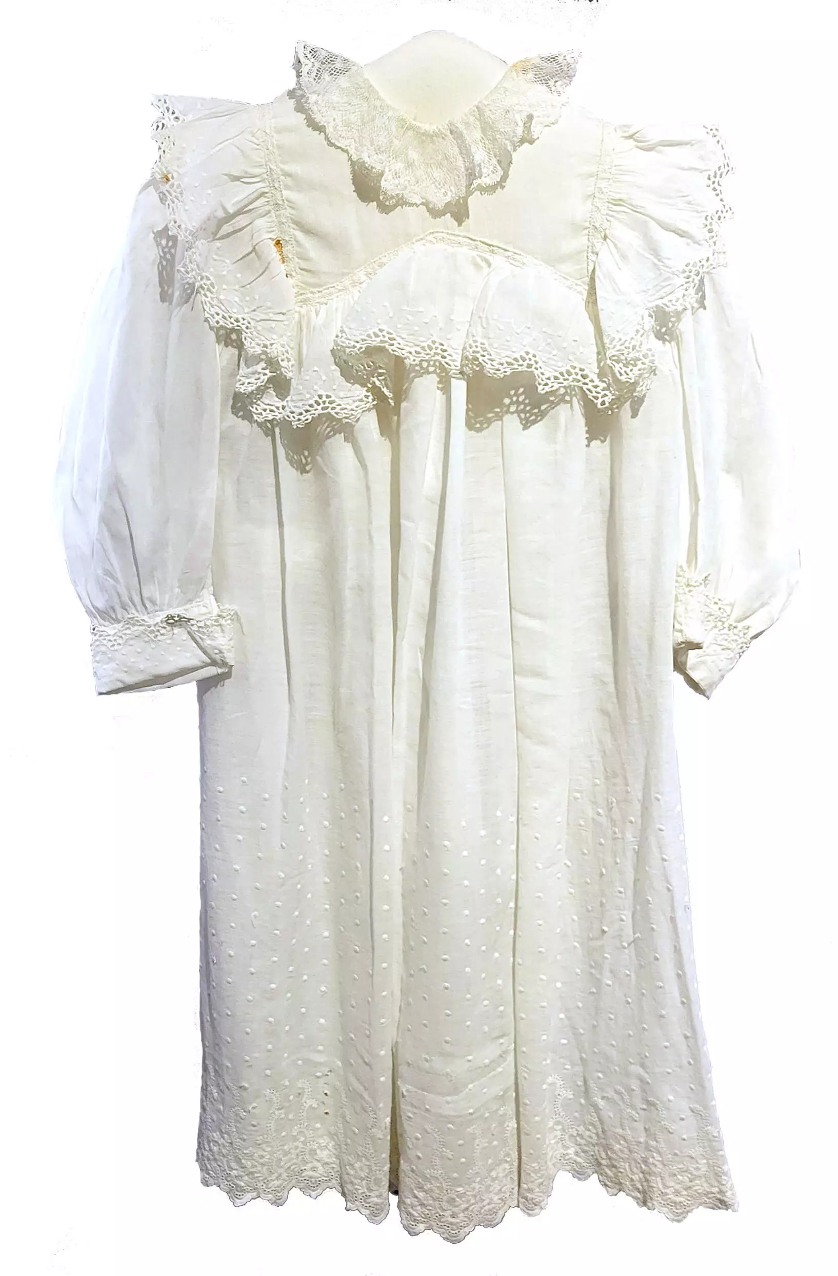A frilly white long-sleeved dress with lace around the shoulders and neck.