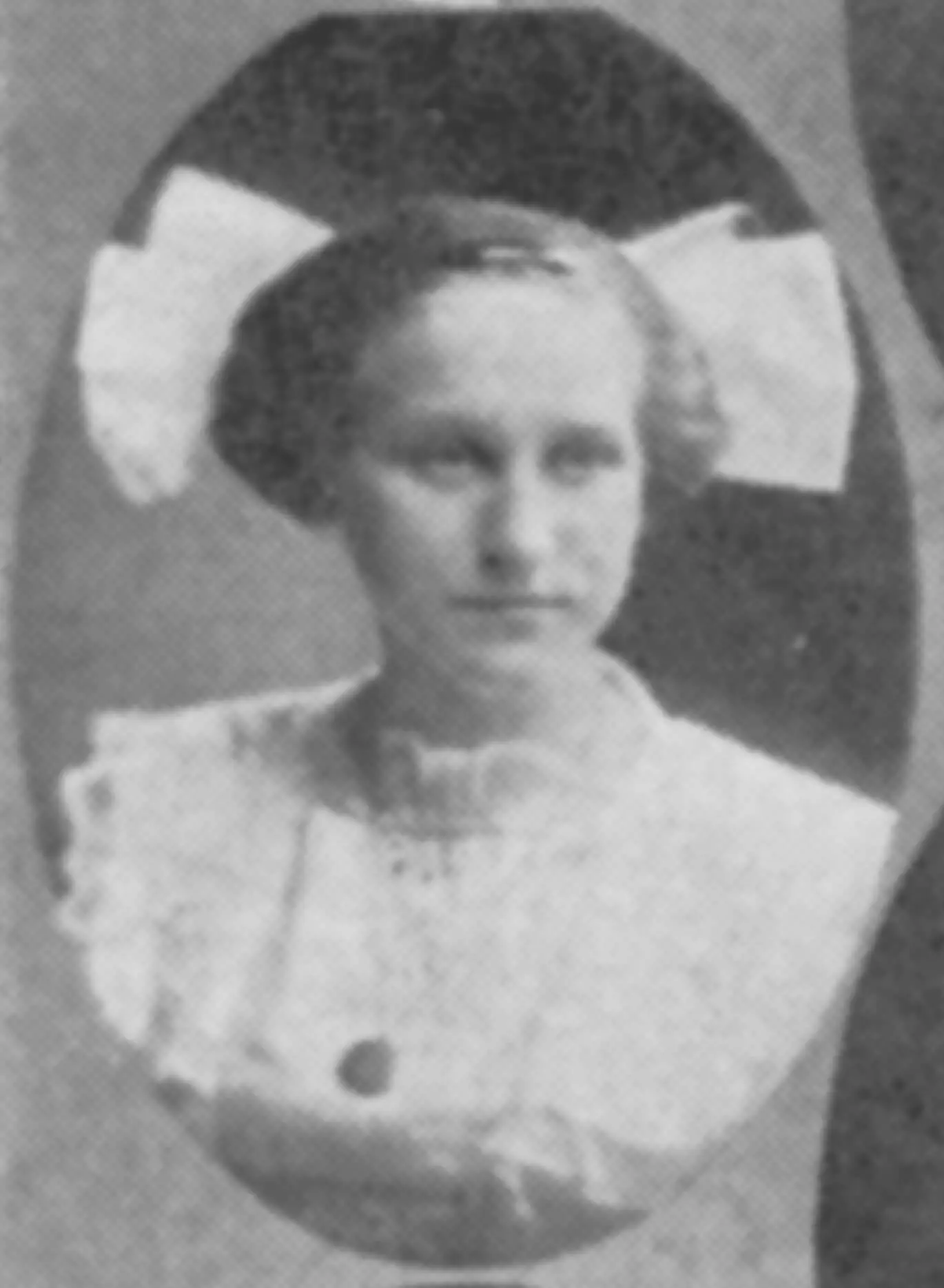 Black and white portrait of a light-skinned young woman with a white dress, necklace, and big white bow on the back of her head, sticking out of the sides of her head.