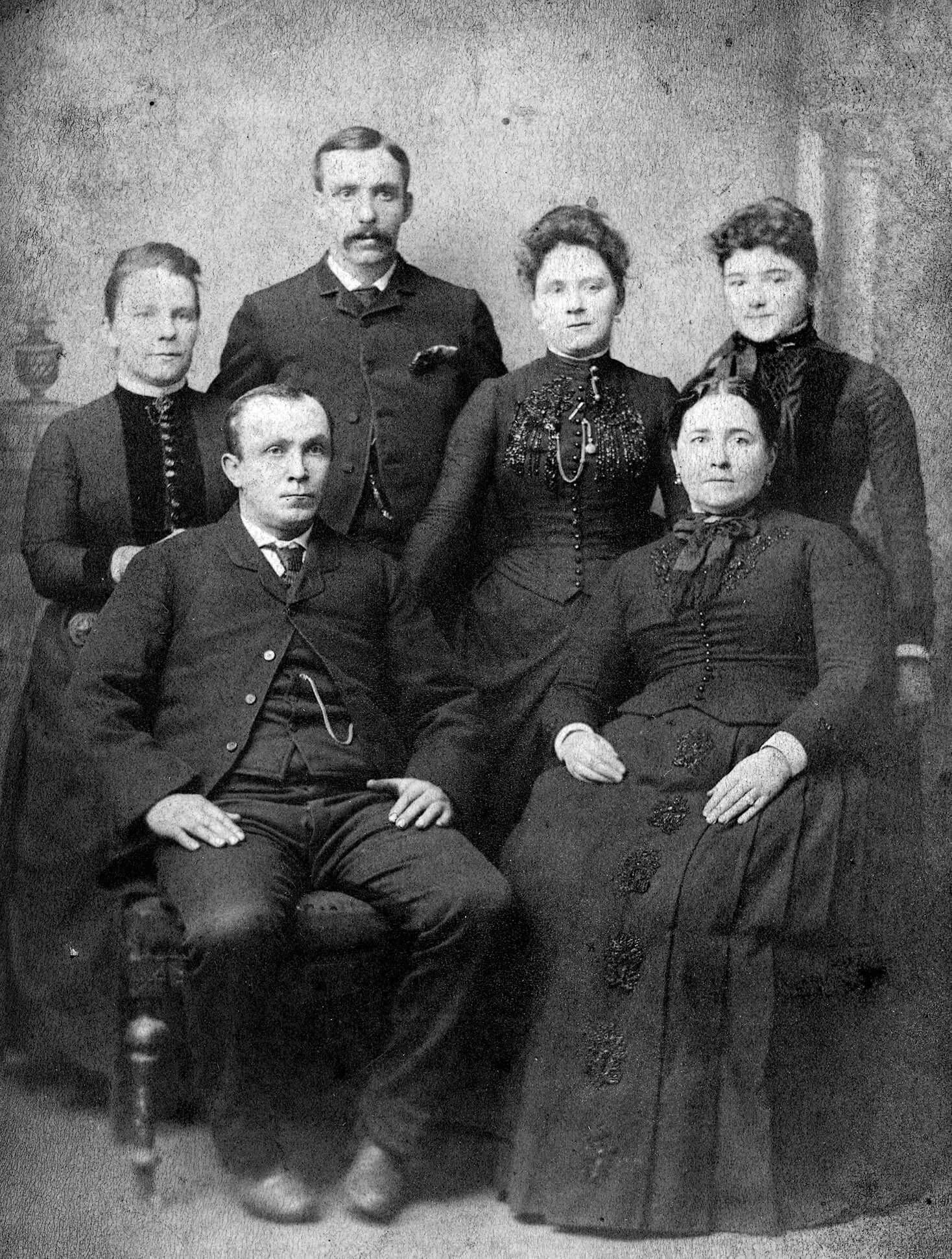 Photo of light-skinned men and women all wearing black.