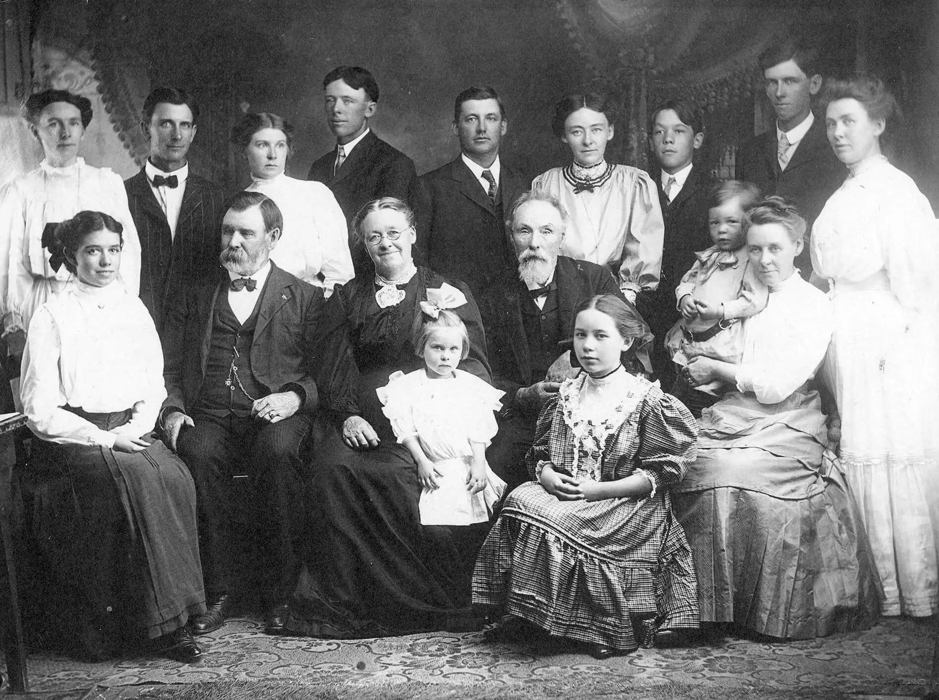 Black and white photo of 17 members of the family, dressed formally.