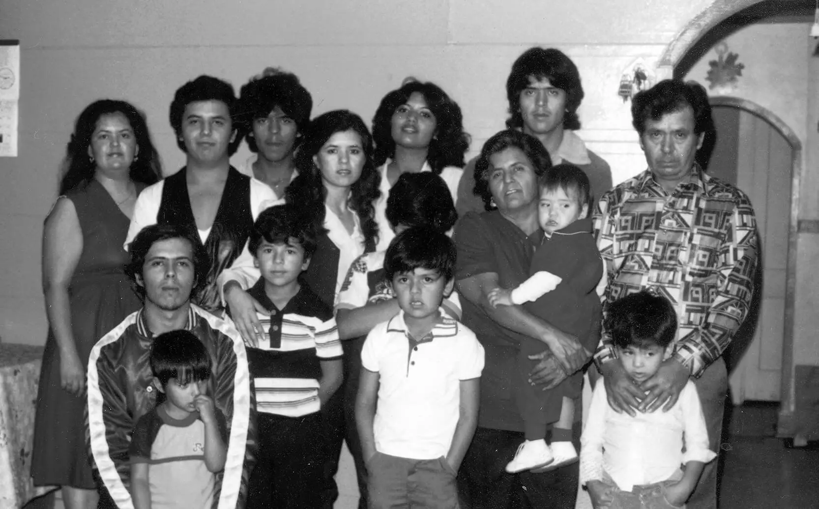 Black and white family portrait featuring 15 individuals. The photo was taken around 1980.