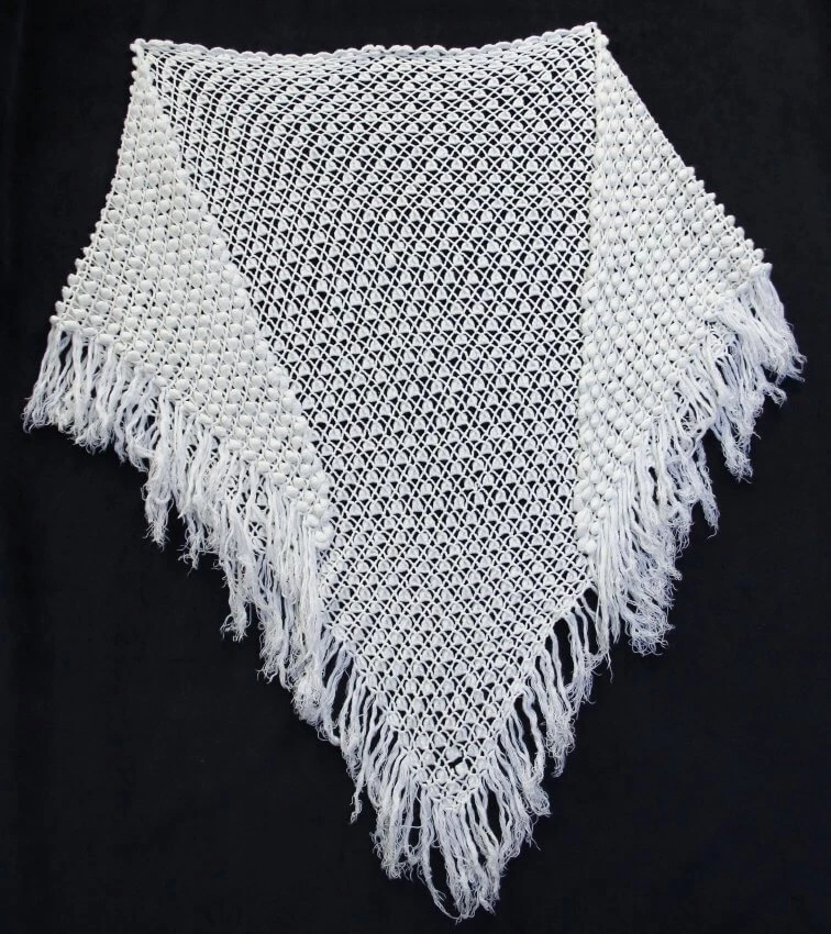 Photo of a lace-knit shawl made of white yarn.