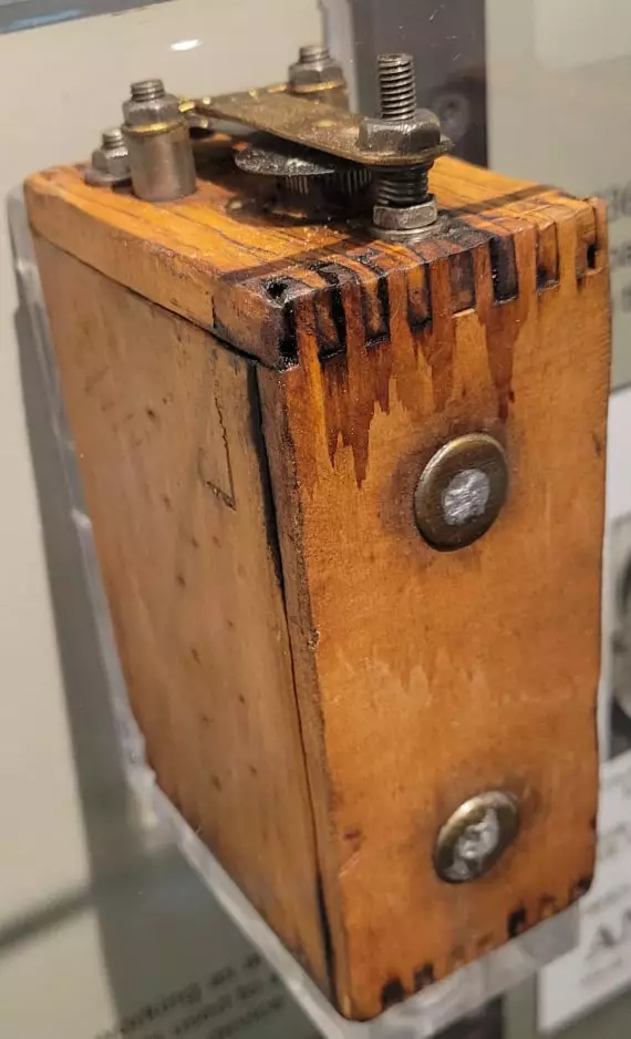 a wooden box with metal pieces coming out of the top.