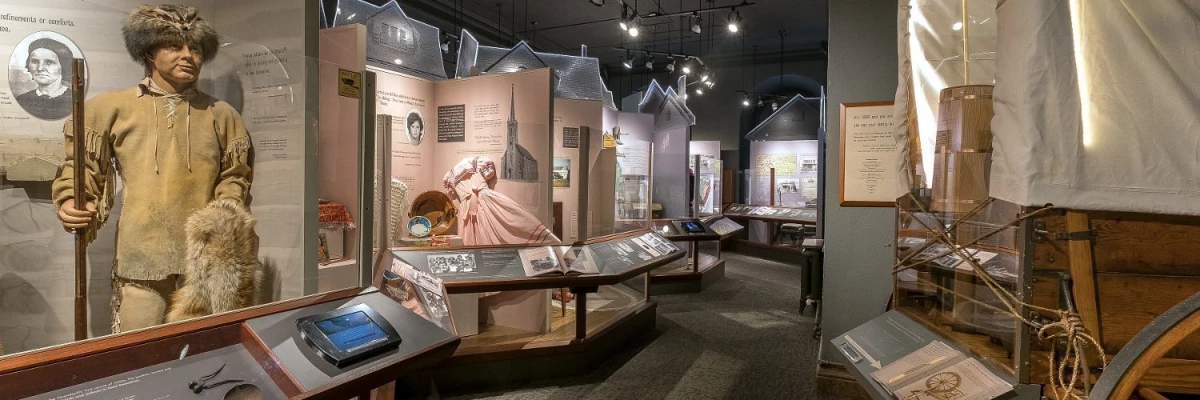 this image shows the interior of our Making a Home exhibit, with a covered wagon on the right.